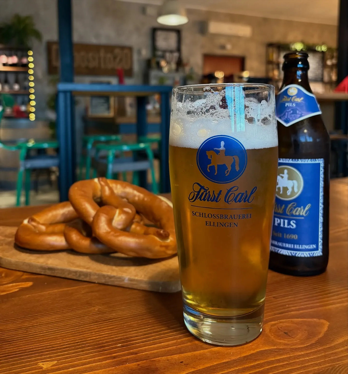 Un boccale di birra con dei brezel sul bancone