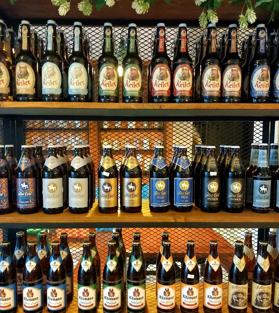 Gli scaffali in legno di Deposito20 pieni di bottiglie di birra